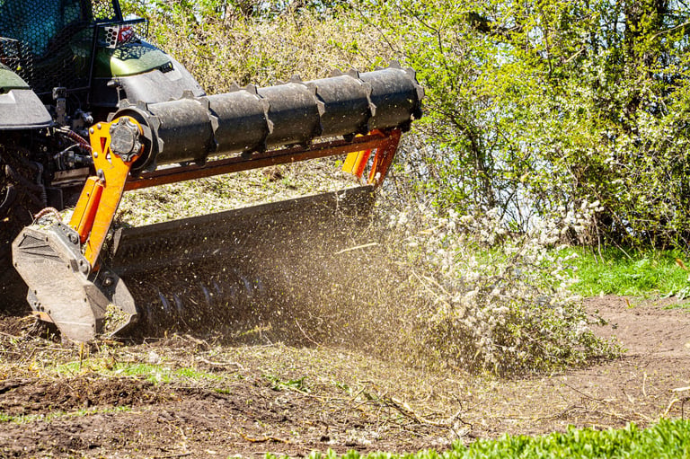 Forestry mulching cutter head on excavator working on roadside vegetation